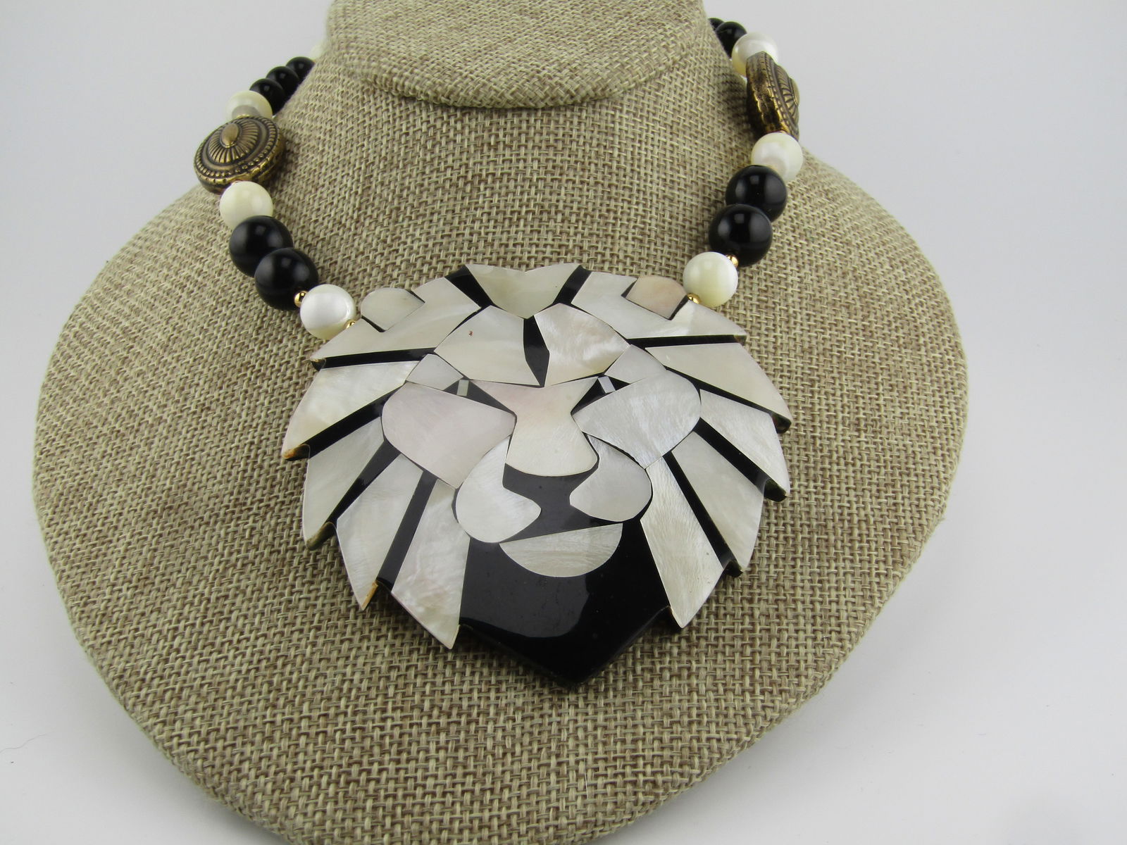 Vintage Lee Sand MOP Lion Beaded Necklace 22", 1970's-1980's: Vintage Lee Sand MOP Lion Beaded Necklace 22", 1970's-1980's. The lion is black with inlaid white mother-of-pearl features to create the lion head. The pendant is appx. 3" talla nd 3.25" wide. The bea