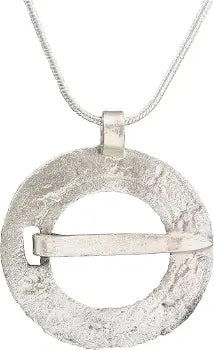 VIKING PROTECTIVE BROOCH, 10th CENTURY AD: 10th century AD. Silvered bronze, over 1 1/8" diameter, relief decorated with incised borders and a series of stars or flowers in the field. The rim notched for its cross pin which is intact. Surface