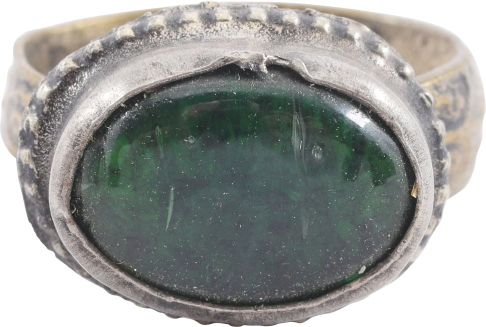 EASTERN EUROPEAN GYPSY RING, SIZE 7 3/4: 19th century. Size 7 ¾. White metal band, 5.4mm width band, flaring to the foliate decorated shoulders. Large oval bezel with cabled bottom and raised central green "stone". Shows wear from use
