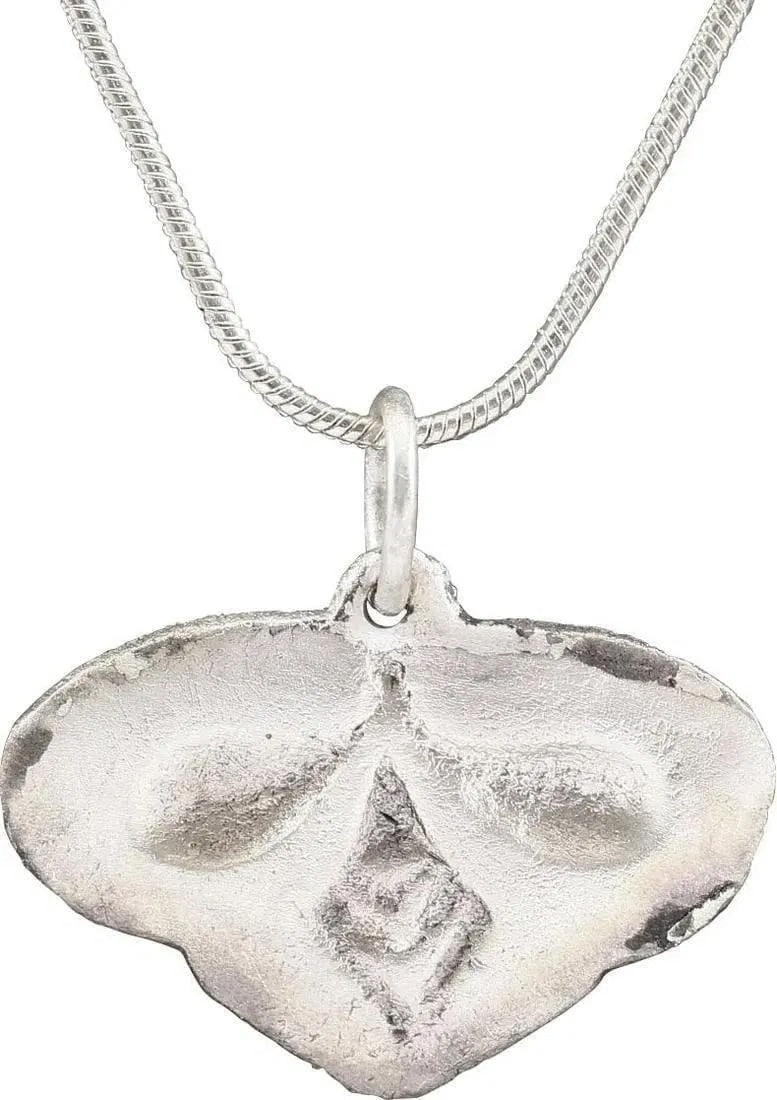 FINE ANCIENT VIKING HEART PENDANT NECKLACE, C.900-1000 AD: About 1" width of somewhat stylized form. Broad borders that meet forming the cusped top. The field with a relief trefoil formed by the borders. The bottom " leaf" with crisp chevron motifs. Well-roun