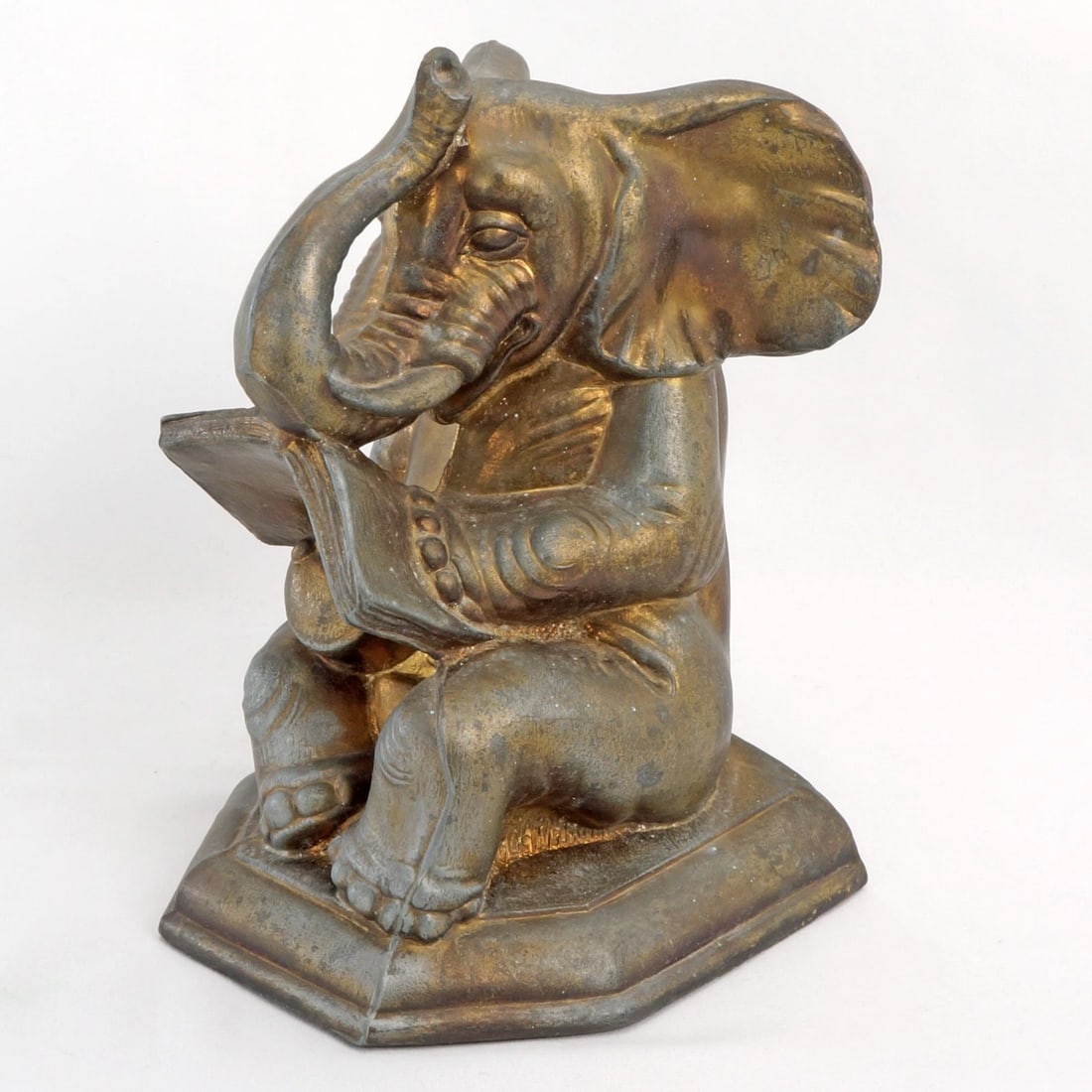 Single Elephant Reading Book Bookend: Title:Single Elephant Reading Book BookendSize:4 1/4 in (10.8 cm) wide x 4 3/8 in (11.0 cm) deep x 6 1/4 in (15.9 cm) tall.Description:An amusing bookend in the shape of an elephant reading a book.