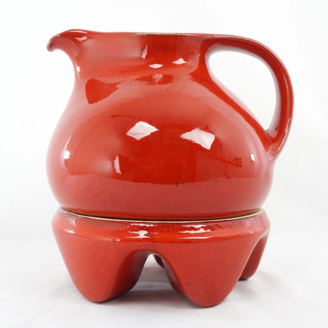 1960s MCM German Ceramic Pitcher and Stand: Title:1960s MCM German Ceramic Pitcher and StandSize:7 3/4 in (19.7 cm) long x 7 in (17.8 cm) diameter x 7 7/8 in (20.0 cm) tall with base.Description:A colorful mid-century design pitcher and