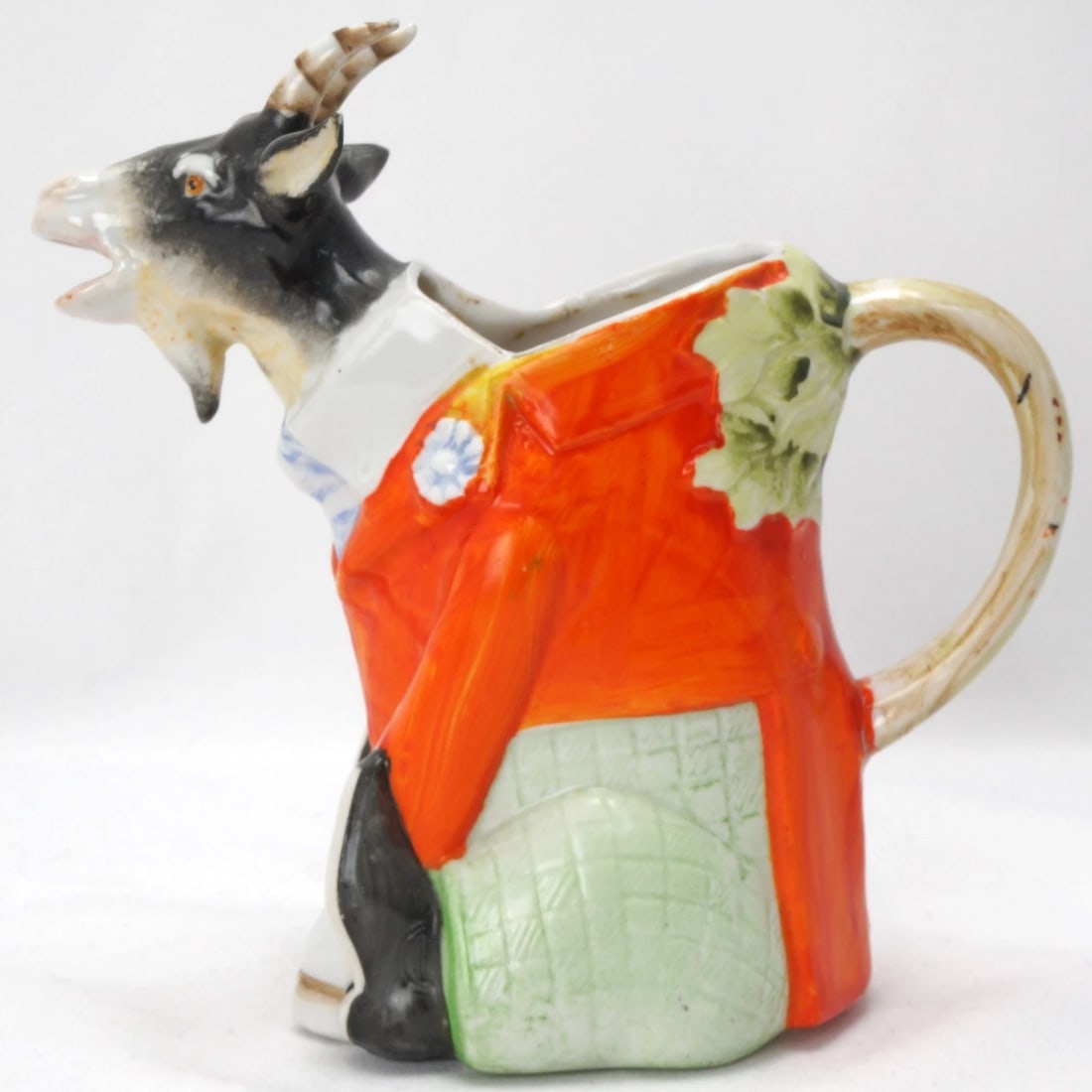 Schaffer & Vater Seated Billy Goat Creamer Germany 1920s: Title:Schaffer & Vater Seated Billy Goat Creamer Germany 1920sSize:5 1/2 in (14.0 cm) deep x 2 7/8 in (7.3 cm) wide x 5 1/2 in (14.0 cm) tall.Description:A whimsical hand-painted creamer in the shape