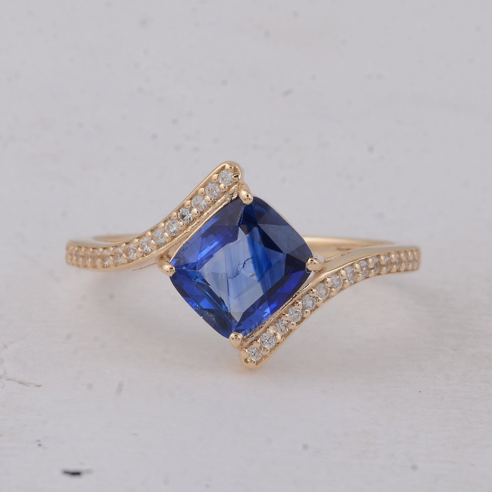 1.65 Ct Cushion Sapphire 9K Gold Ring: 1.65 Total Carat Sapphire 9K Gold Ring Specifications - Total Weight 1.878 g - Center Gemstone Sapphire - Gemstone Carat Weight 1.52 Carats - Gemstone Measurements 7.10X6.30X3.30 mm - Additional Gemst
