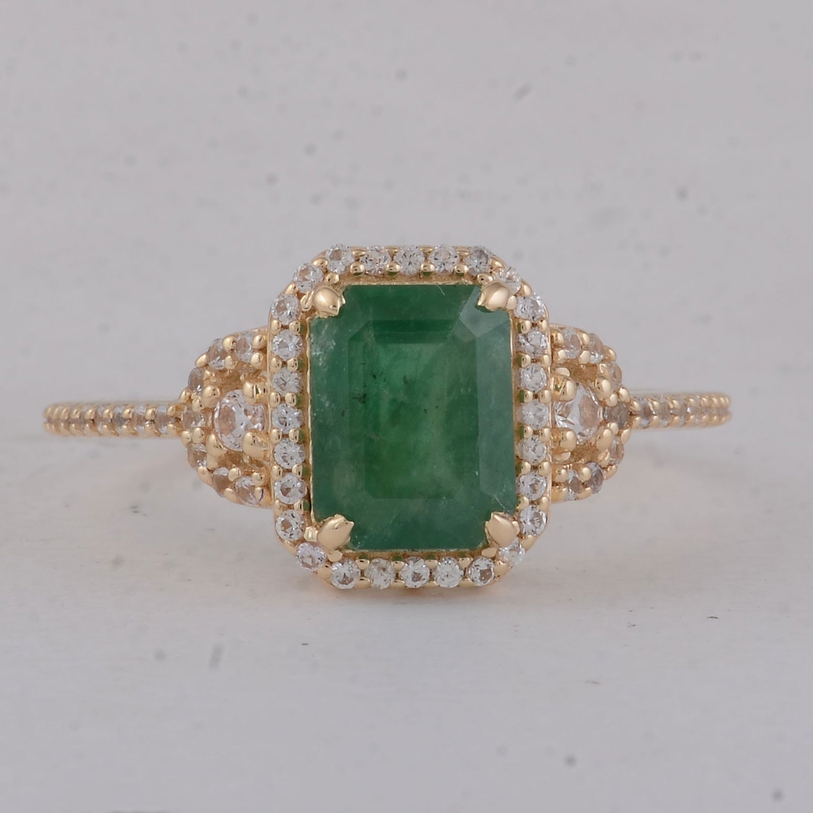 1.89 Ct Octagon Emerald 9K Gold Ring: 1.89 Total Carat Emerald 9K Gold Ring Specifications - Total Weight 2.19 g - Center Gemstone Emerald - Gemstone Carat Weight 1.57 Carats - Gemstone Measurements 8X6 mm - Additional Gemstones White Sap