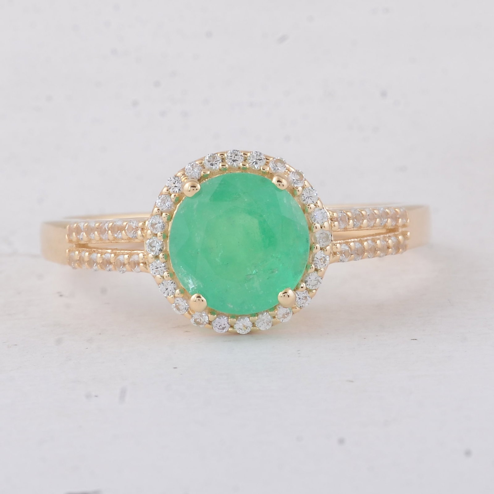 1.58 Ct Round Emerald 9K Gold Ring: 1.58 Total Carat Emerald 9K Gold Ring Specifications - Total Weight 2.41 g - Center Gemstone Emerald - Gemstone Carat Weight 1.38 Carats - Gemstone Measurements 7 mm - Additional Gemstones White Sapph