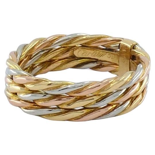 Cartier Les Must de Cartier 18k Gold Trinity Braided Ring: About the Item An elegant and timeless Cartier Les Must de Cartier trinity ring, crafted in 18k yellow, white, and rose gold. The iconic design features three interlaced braided bands, symbolizing
