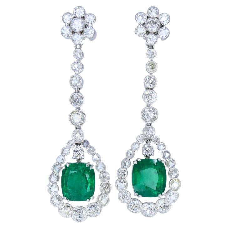 Art Deco Drop Earrings Platinum Diamond Emerald Cushion Cut Estate Jewelry: About the Item Impressive Art Deco drop earrings, made of platinum, featuring diamonds and cushion cut emeralds. Each emerald is surrounded by a halo of Old European and rose cut diamonds. The open