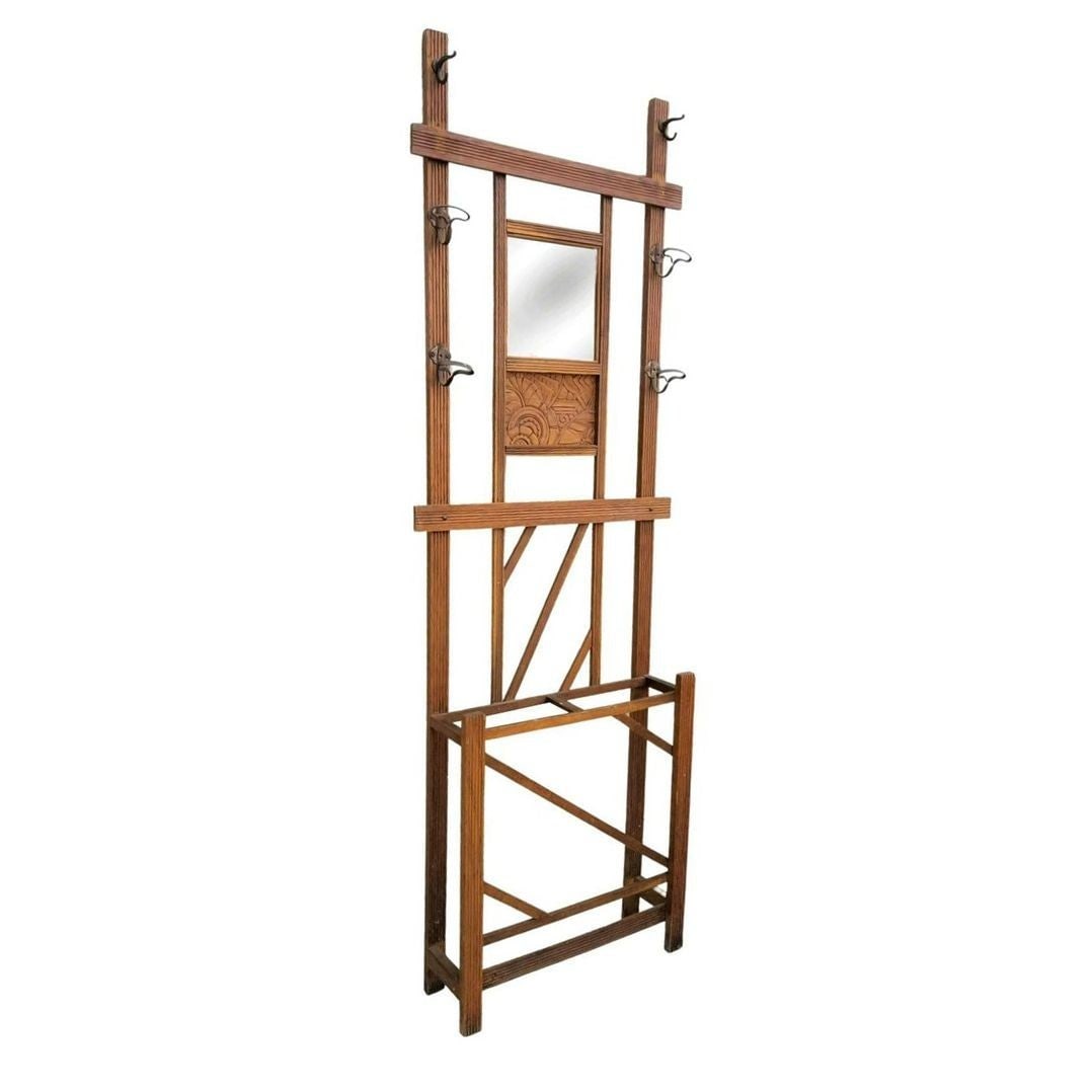Art Deco Carved Rack Hall Tree with Mirror: Title: Art Deco Carved Rack Hall Tree with Mirror Description: Early carved wood Art Deco wooden entryway hall tree with a bottom umbrella stand featuring 6 large hooks, a mirror, and a centerpiece wo