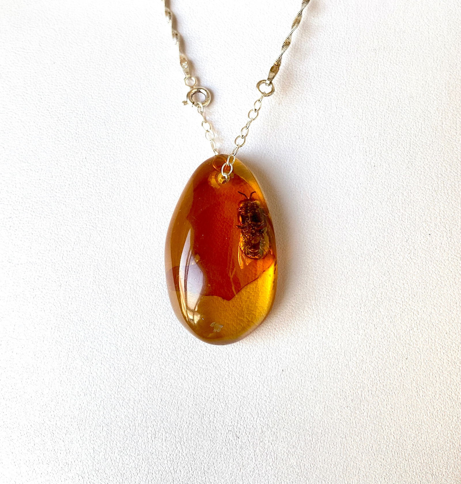 Splendid Amber Pendant with chain, shaped like a Drop with a Bee: Title:Splendid Amber Pendant with chain, shaped like a Drop with a BeeMetal:Sterling SilverGemstone:AmberWeight:11.5 gSize:Size: 43.0 x 25.0 x 11.6 mm Size: 1.693 x 0.984 x 0.457 inches Made