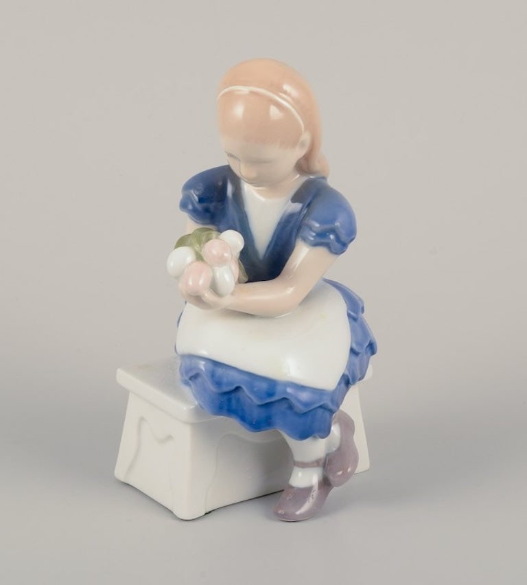 Bing & Grøndahl, Danmark. Porcelain figurine of seated girl with a bouquet of flowers in her: Title: Bing & Grøndahl, Danmark. Porcelain figurine of seated girl with a bouquet of flowers in her arms. Mid-20th century. Description: Bing & Grøndahl, Denmark. Porcelain figurine of
