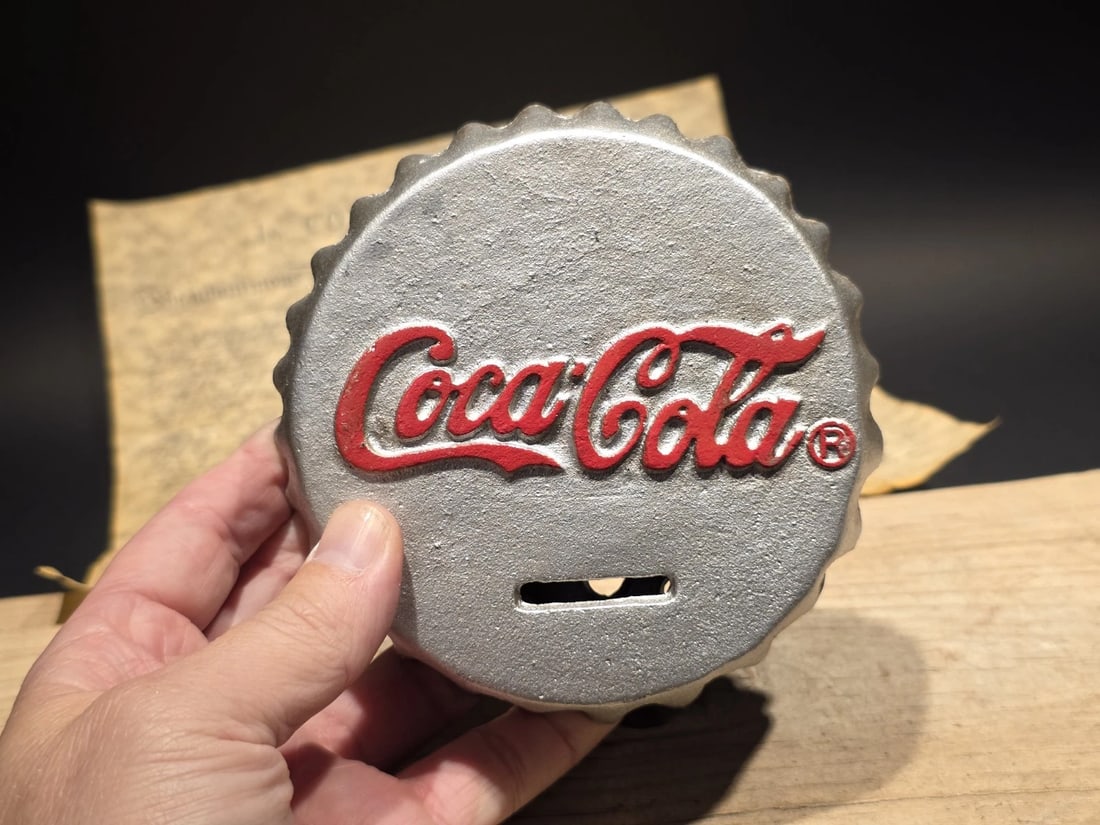 Cast Iron Coca Cola Bottle Cap Coin Bank Atlanta Ga.: Title:Cast Iron Coca Cola Bottle Cap Coin Bank Atlanta Ga.Description:5 1/4" Wide Nice reproduction cast iron coca cola bottle cap coin bank. Slightly aged to look old. Hard to tell its age for sure!