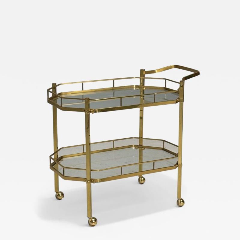 Hollywood Regency Style, Brass, Glass, Bar Cart, France, 1970s: Title: Hollywood Regency Style, Brass, Glass, Bar Cart, France, 1970s Description: Hollywood Regency Style, Brass, Glass, Tiered Bar Cart, France, 1970s A mid-century modern bar cart designed and prod