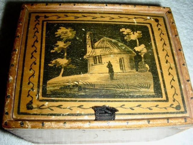 Small 19th C Trinket Box w/ Hand-Painted Lid: A small and charming 19th century Trinket Box with a hand-painted lid of a cottage with a figure standing in front of it. This little box, which is canted, measures 3 ½” x 3” x 1