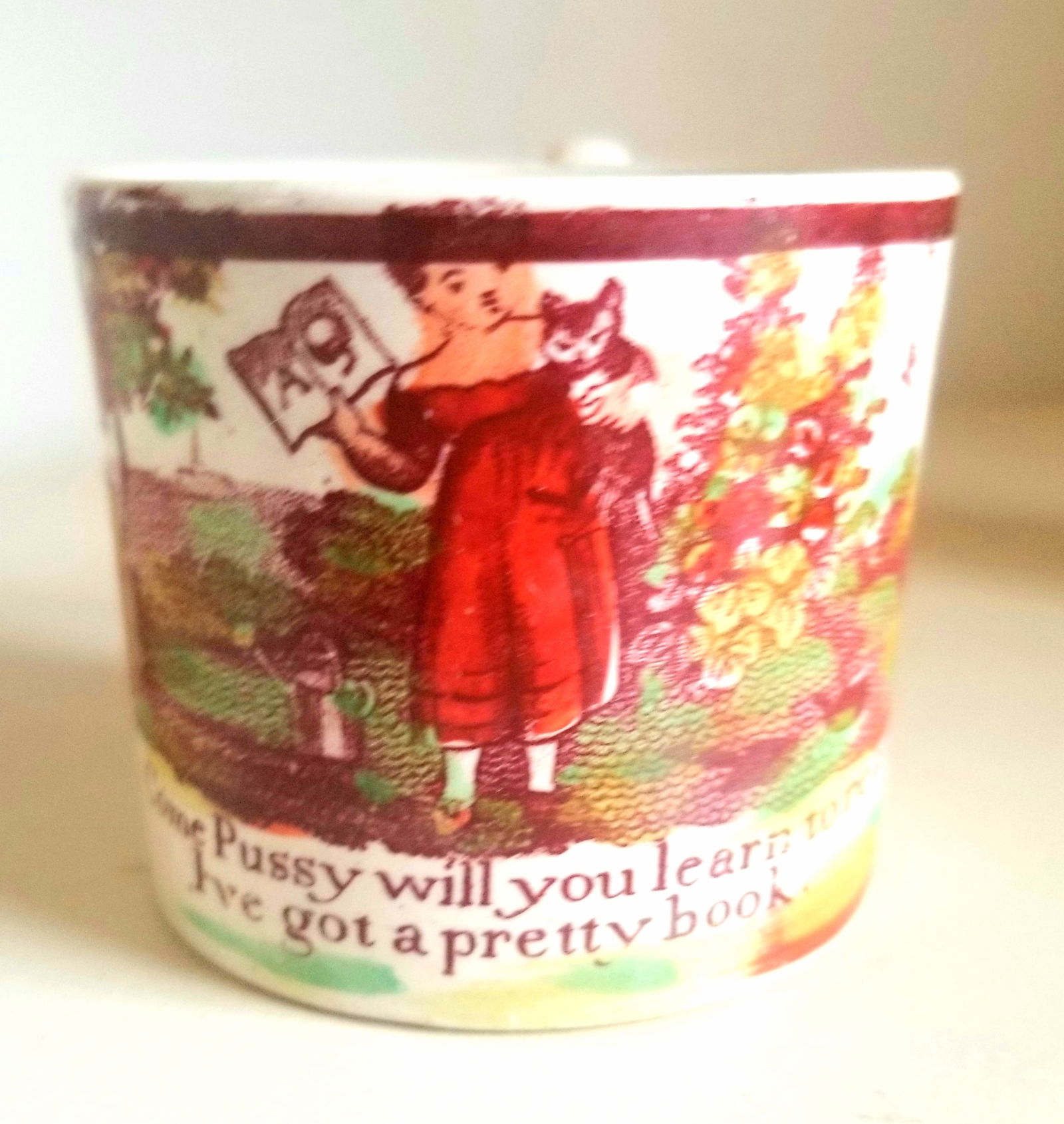 Child's mug, England: Great verse! A girl and her kitty, tall flowers, watering can, etc. Paper label with date, 1826. Shipping:Domestic: Shipping rates are determined by destinationInternational: