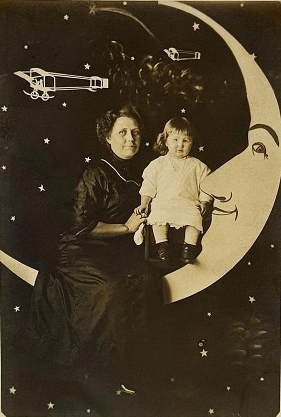 RPPC Real Photo Paper Moon Postcard Woman Child Biplanes Stars Cute Moon 1900: Real photo Paper Moon postcard showing a woman and a child on a cut-out studio paper moon. There are stars and two biplanes in the background. The moon is smiling and quite adorable. Card is in very