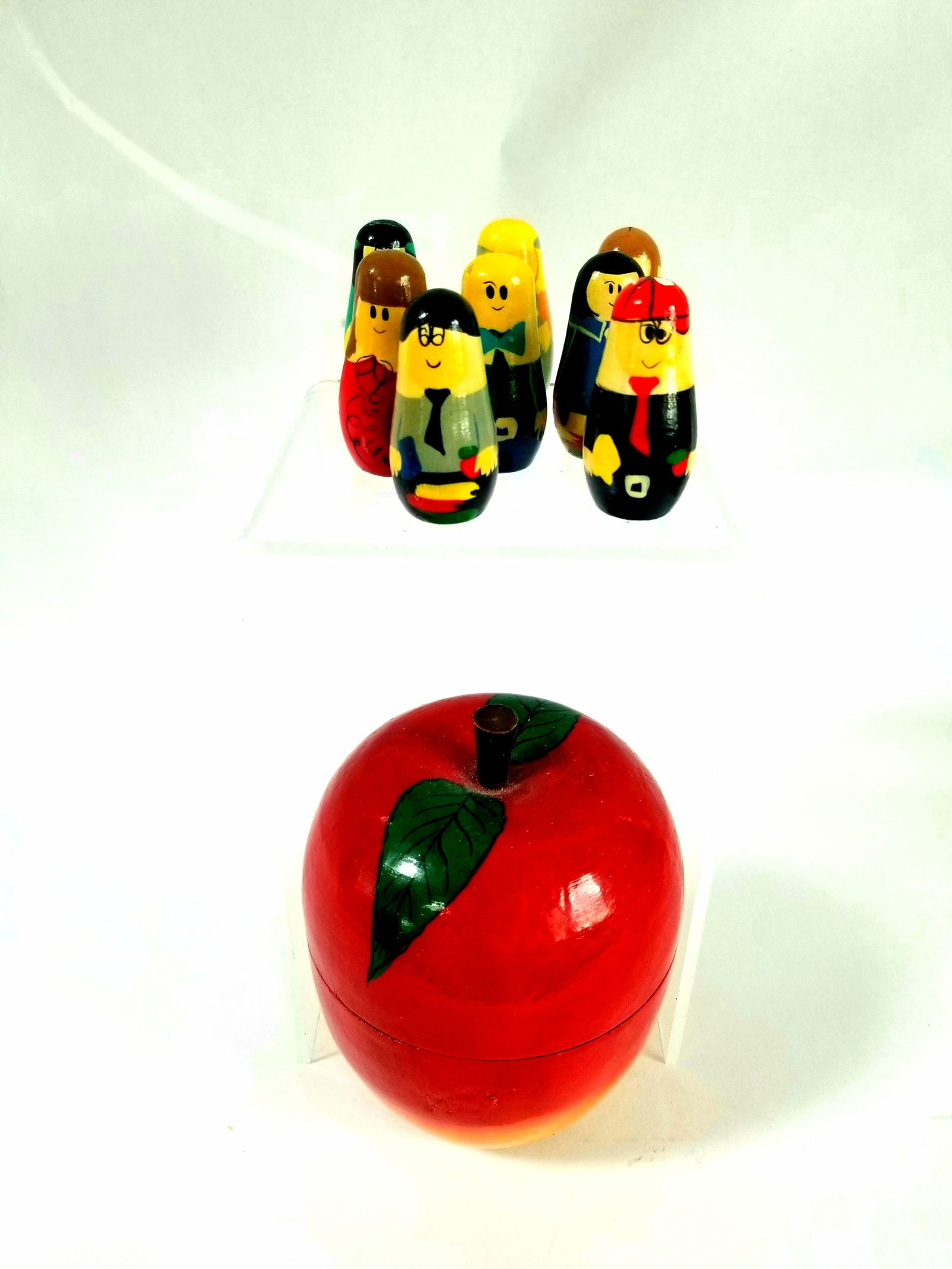 Wooden painted apple box and 8 dolls: Paint flaking on the top of one doll's head, as shown. Apple 4" high and glossy. The dolls fit inside the apple. Shipping:Domestic: Flat-rate of $15.00 to anywhere within the contiguous