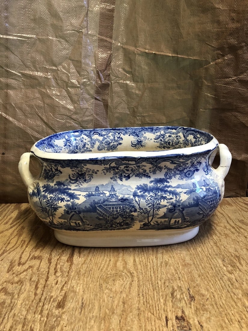 Staffordshire Footbath: It measures 19 1/2” x 13” x 8 1/2” and dates around the 1830’s. It has one handle reglued and a tight 2” hairline and a tight 4” hairline on the bottom along the