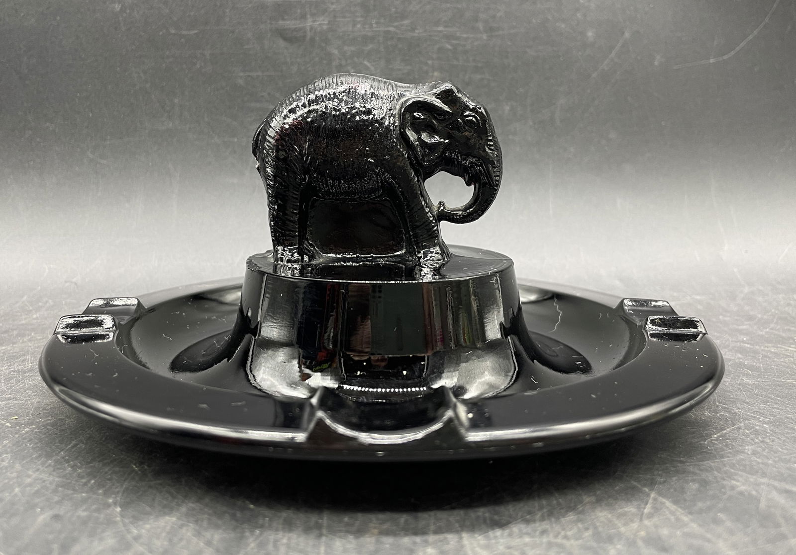 LE SMITH GLASS ELEPHANT ASHTRAY TRINKET DISH: Date/Period: unknown Dimension: Approx 3 x 6.5 Material: glass Additional Information: LE SMITH EBONY BLACK GLASS (with a slight reddish tint) ELEPHANT ASHTRAY VINTAGE TRINKET DISH Shipping: Domestic: