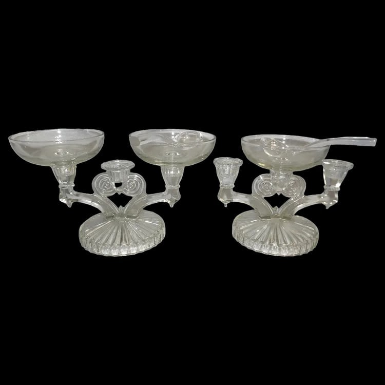 Jeanette Glass Cosmos Triple Candelabra pair: Art Deco style triple candle holder with 3 inserts and two glass spoons. Produced in the 1940s. Features a central heart shape under the center candle. Measures 10.75” x 6” x 4.6”. 