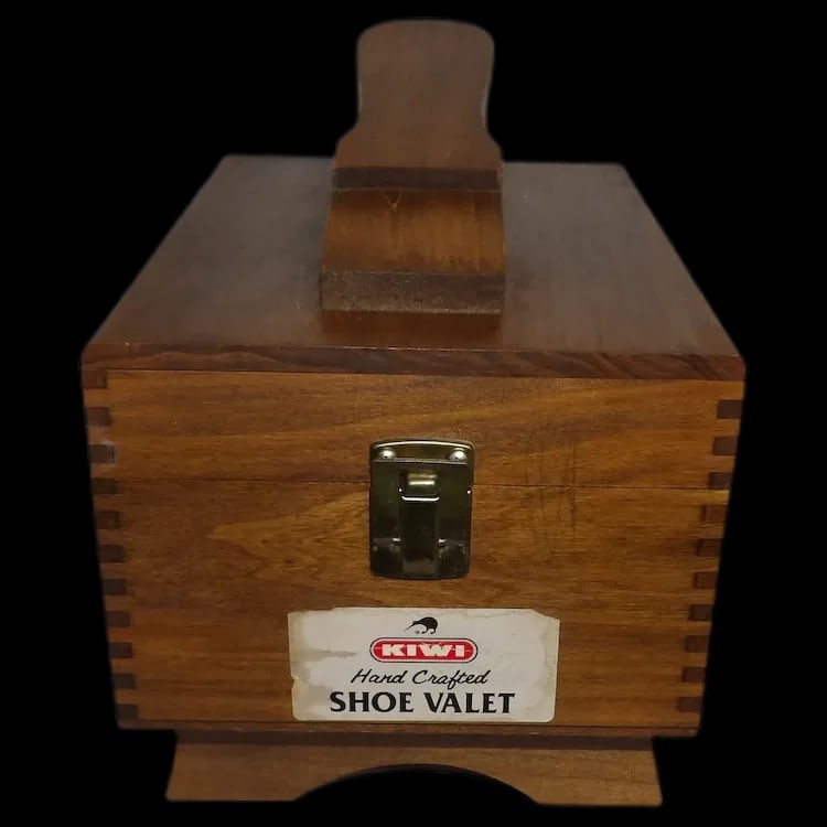 Kiwi Hand-Crafted Oak Shoe Valet: Vintage oak shoeshine box with interlocking joints, brass hardware, and a footrest handle. Includes brushes, polish dabbers, and various tins of polish. Shipping:Domestic: Flat-rate of $20.00 to