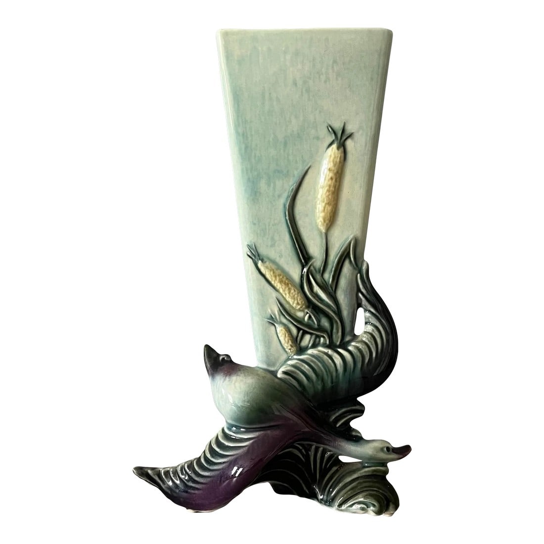 1990s Hull Pottery Swan Vase: Beautiful 1990s Hull pottery triangular vase depicting a swan (or goose) in flight. This vase is in perfect condition. Varying shades of blues, greens and purples truly set this vase apart. The triang
