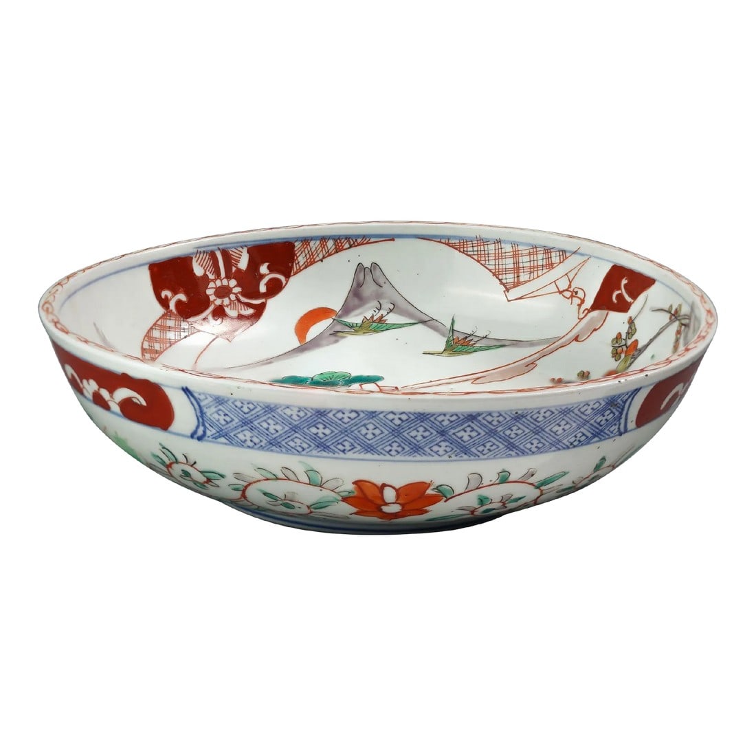 Meiji Period Japanese Arita Bowl, C. 1850-1900: Imari palette shallow bowl decorated in Imari colors simulating the Chinese famille verte palette (green with accents of aubergine, oxide red and underglaze blue). The interior of the bowl is