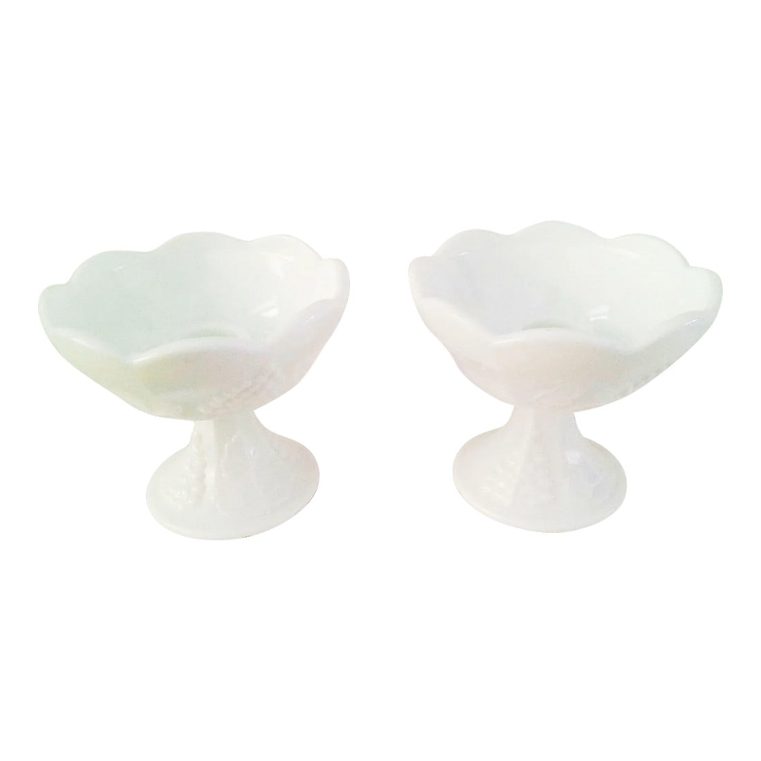 Mid-Century Harvest Grape Milk Glass Candle Holders, a Pair: Charming pair of 1950s Westmoreland milk glass candle holders in the "Harvest Grape" pattern. Set features a raised grapevine motif around perimeter with scalloped rims. Each holds one taper candle. 