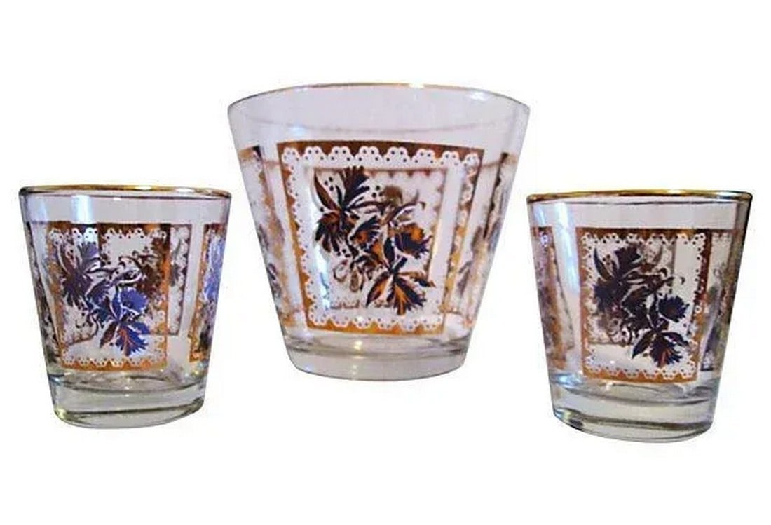 Mid-Century Purple Iris Ice Bucket & Glasses, Set of 3: 1950s glass ice bucket and two whiskey glasses (3.25"H x 3"Dia) featuring a motif of purple and white irises around the perimeter with generous gold-gilt embellishments and rims. Excellent condition.