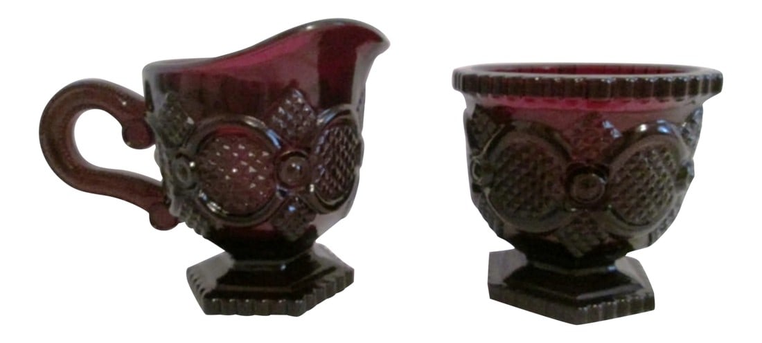 1970s Cape Cod Creamer & Sugar Bowl, a Pair: Beautiful dark-ruby creamer and sugar bowl in Avon's Cape Cod pattern from the 1970s. Excellent condition. Dimensions: sugar bowl, 3.25"H x 3.5"Dia; creamer, 5.25" L x 3" W x 3.75" H. Condition: