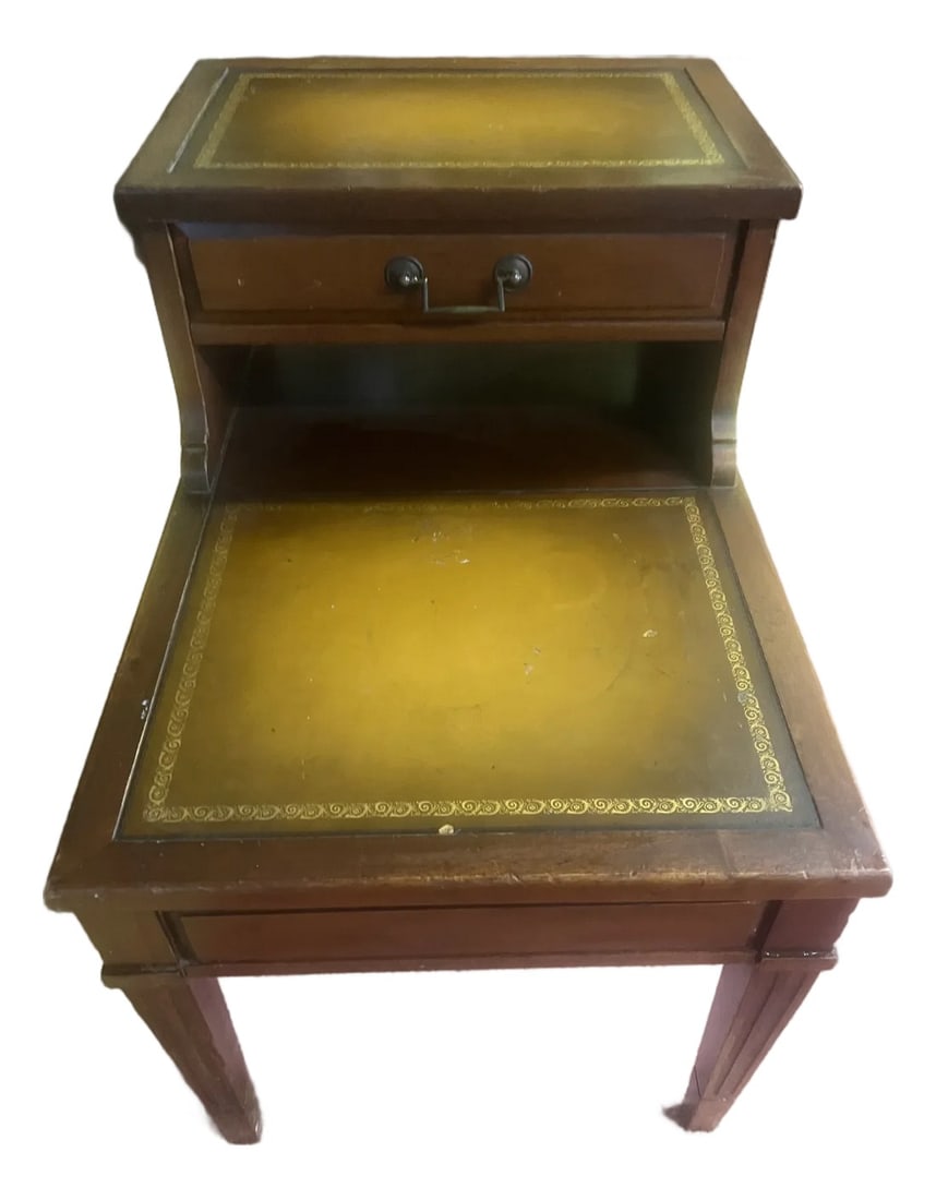 1960s Classic Mahogany Mersman Leather Side Table With Gold Stencil: Mersman vintage two tier mahogany with leather top insert. Leather top insert with gold stenciling is in good condition . Nice single storage drawer in working condition. The two tier tables