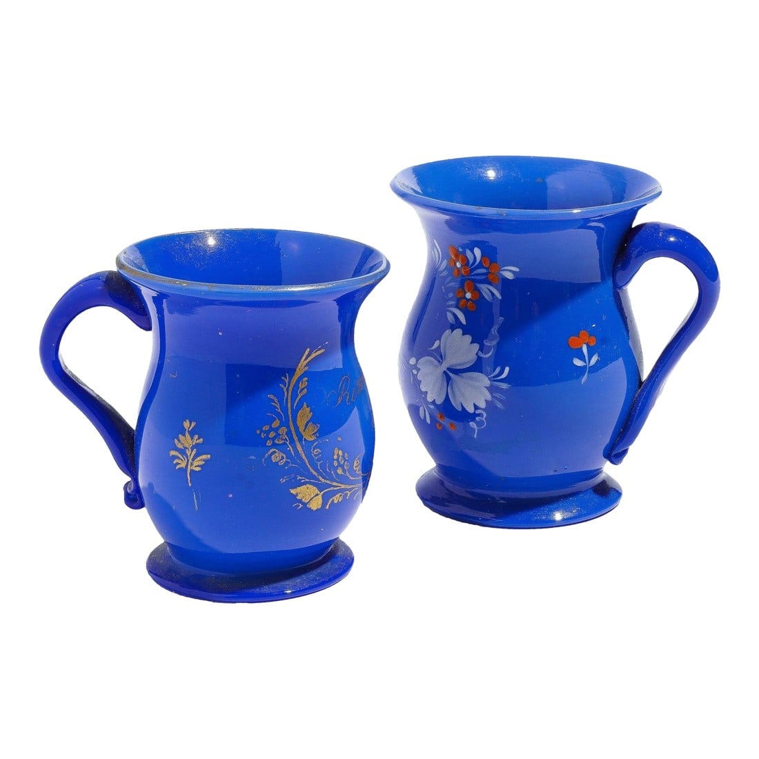 Pair of English Miniature Blue Opaline Blown Glass Mugs, C. 1830: Pair of miniature blue opaline blown glass mugs with applied handle and gilt & enamel decoration. Bristol, England, circa 1830. Dimensions: 3-1/2" L x 2-3/4" W x 3-1/2" H 3-1/4" L x 2-1/2" W x 3" H 