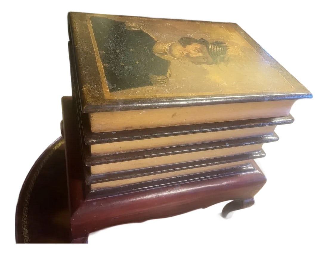 1980s Faux Bookcase Portrait Lift-Top Table: This unique faux book stack lift top table with historic soldier portrait is sure to add some charm to any room - and also storage options. Featuring a historic soldier portrait on the lid and gold
