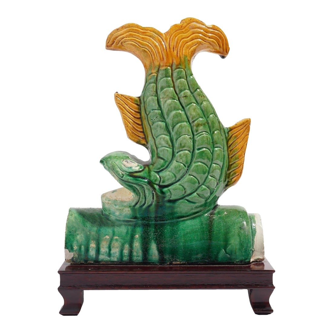 Traditional Chinese Ceramic Fish Form Roof Tile on Stand, C. 1900's: Traditional Chinese ceramic fish form roof tile terminal, glazed in green and marigold yellow & mounted on a mahogany footed stand. China, 20th century. Dimensions: 8-1/4" L x 5-1/4" W x 12" H 