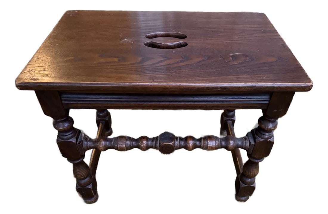 Late 19th Century Rustic Farmhouse Milking Stool: This small, oak stool has turned legs united by cupid bow stretchers. The top has a decorative cut out, which serves as a handle. It features distinctive turned, or "barley twist," legs and a carved