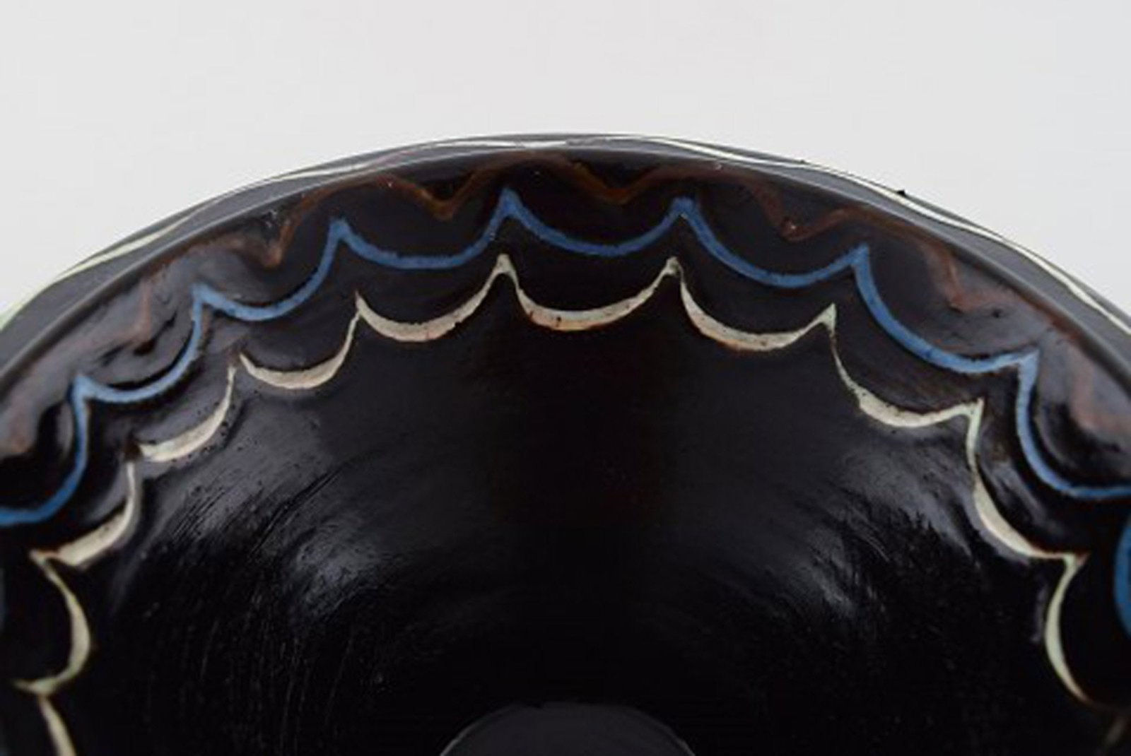 Kähler, Denmark. Bowl in black glazed ceramics with blue and white waves along the edge. 1930s - 4