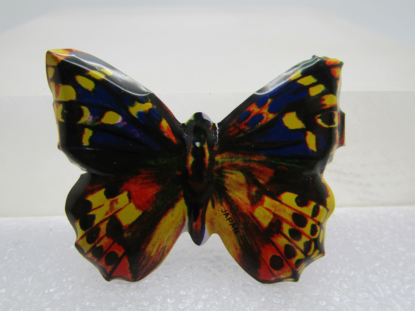 Vintage Litho Butterfly Brooch, 1950's-1960's: Vintage Litho Butterfly Brooch, 1950's-1960's, Metal brooch in yellow, orange, black, and purple. It is appx. 1.75" wide and 1.25" high. C-clasp type pinback. Very good condition. (W93023.3 SS12368 J