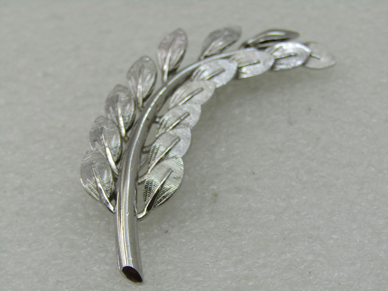 Vintage Danecraft Sterling Leaf Stem Brooch, 2.25" by 5/8" Wide: Vintage Danecraft Sterling Leaf Stem Brooch, 2.25" by 5/8" Wide. Textured leaves on a curved stem wthat is shiny and smooth. 1960's. Signed Danecraft and marked sterling and tested. Weight is appx.