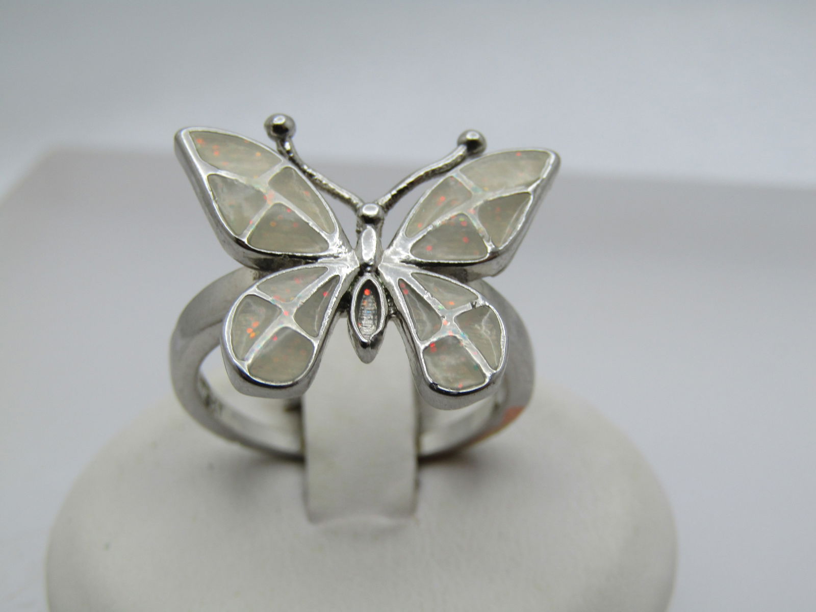 Silver Plated Butterfly Ring, Sz. 8.5, Enameled, 1990's: Silver Plated Butterfly Ring, Sz. 8.5, Enameled, 1990's. the butterfly has white to off white enameled wings with a little shimmer included. It is a silver plated ring that is oddly marked 10kt but is