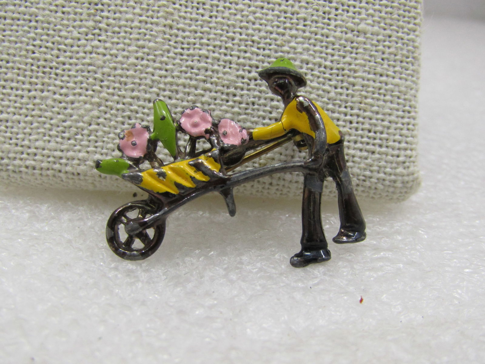 Vintage Enameled Flower Gardener Brooch, 1950's-1960's.: Vintage Enameled Flower Gardener Brooch, 1950's-1960's. Asian themed with a green enameled hat, and yellow wheel barrow and shirt and pink flowers with green leaves. It is 1.25" wide and 1" tall. Some