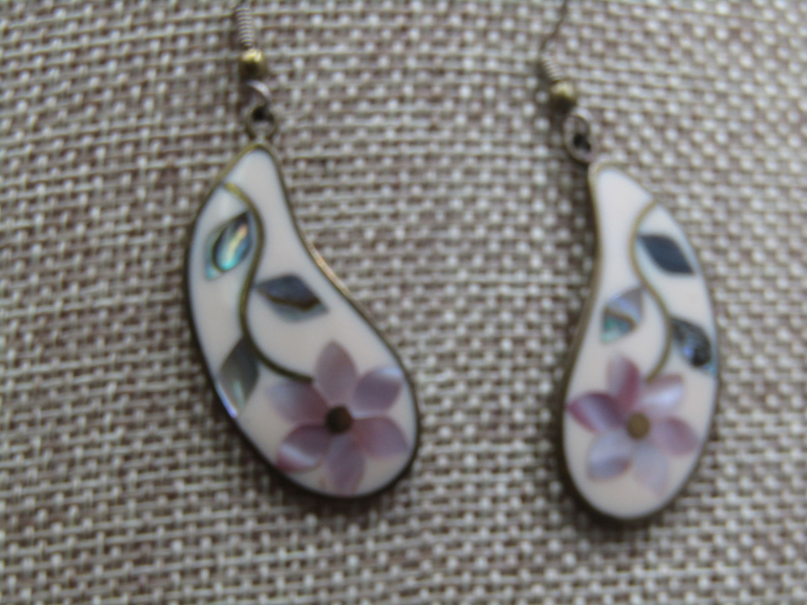 Vintage Alpaca Inlaid Floral Earrings signed Alia, Mexico: Vintage Alpaca Inlaid Floral Earrings signed Alia, Mexico curved design that are appx. 2.25" from the curve in the hook to the botton of the drop. White background with inlaid mother-of-pearl pink