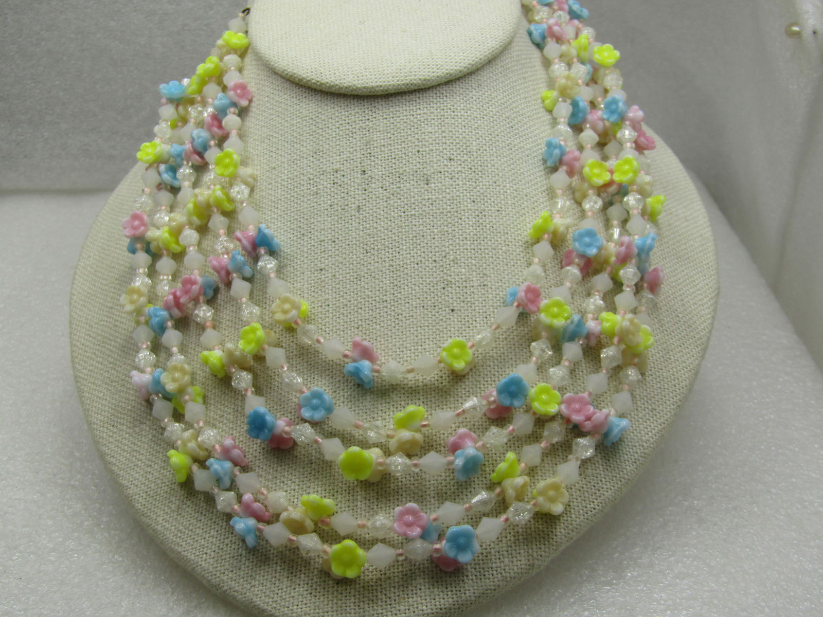 Vintage Five Strand Floral Beaded Necklace, 18", Germany: Vintage Five Strand Floral Beaded Necklace, 18", Germany. Mid-Century. Pastel yellow blue, pink flowers with white, clear diamond shaped beads between. Thse beads are a plastic construction and are fi
