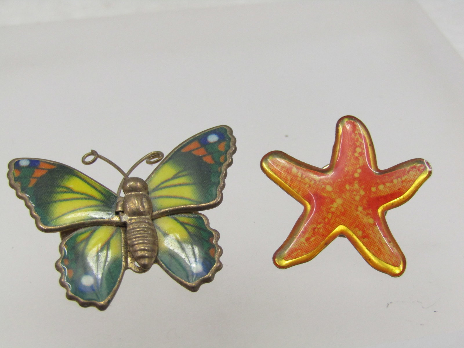Vintage Enameled Butterfly Brooch & Star Fish Tack Pin: Vintage Enameled Butterfly Brooch & Star Fish Tack Pin. The butterfly is papx. 1950's-1960 enameled in greens/yellow, orange, C-clasp. It is appx. 1.25" wide and 1" tall. The starfish tack pin is gold