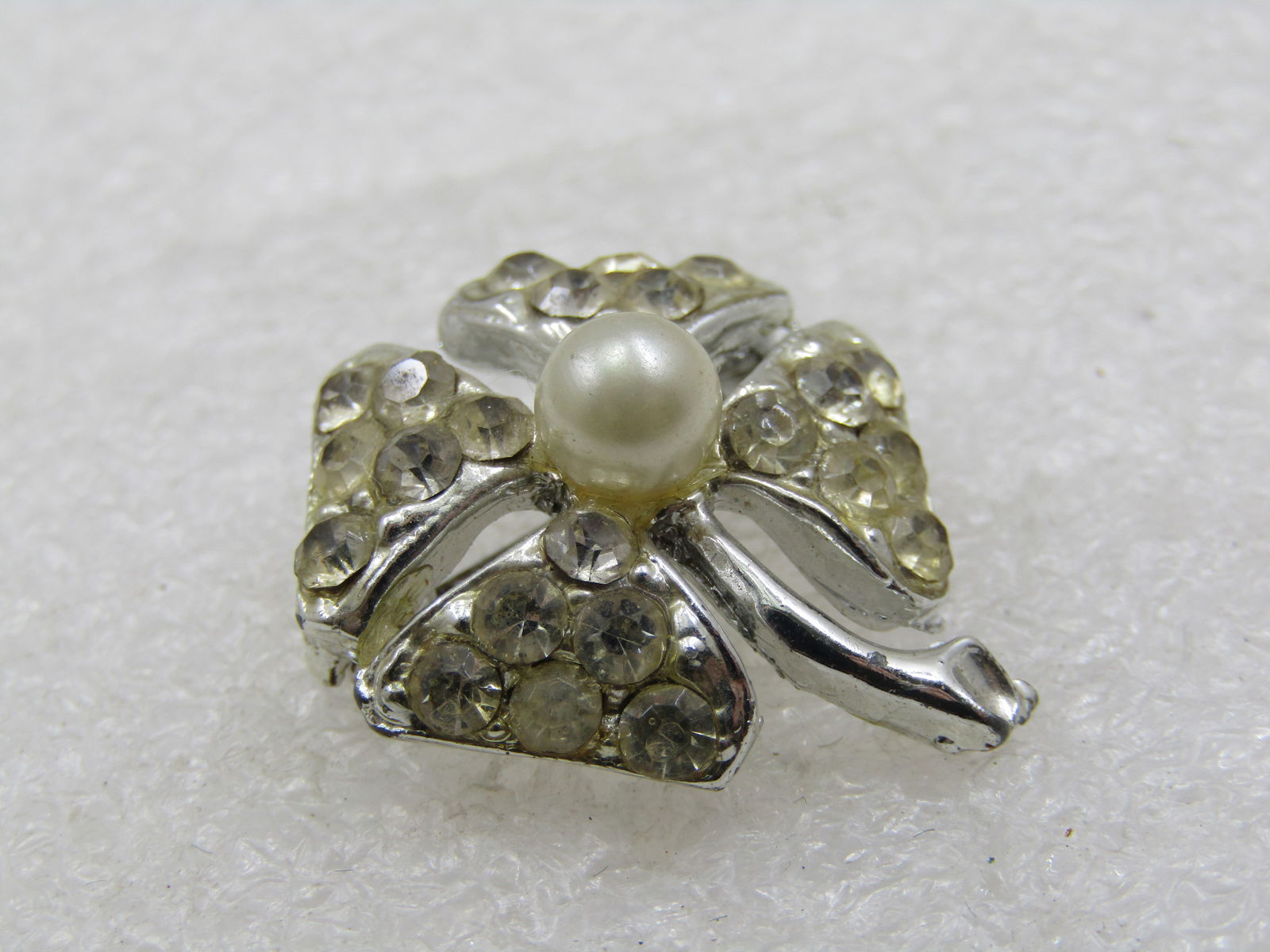 Vintage Rhinestone & Faux Pearl Four Leaf Clover Brooch, 1920's-1930's: Vintage Rhinestone & Faux Pearl Four Leaf Clover Brooch, 1920's-1930's, Appx. 1" tall and white with four petals that have six rhinestones in each petal with a center raised faux pearl that is appx. 5