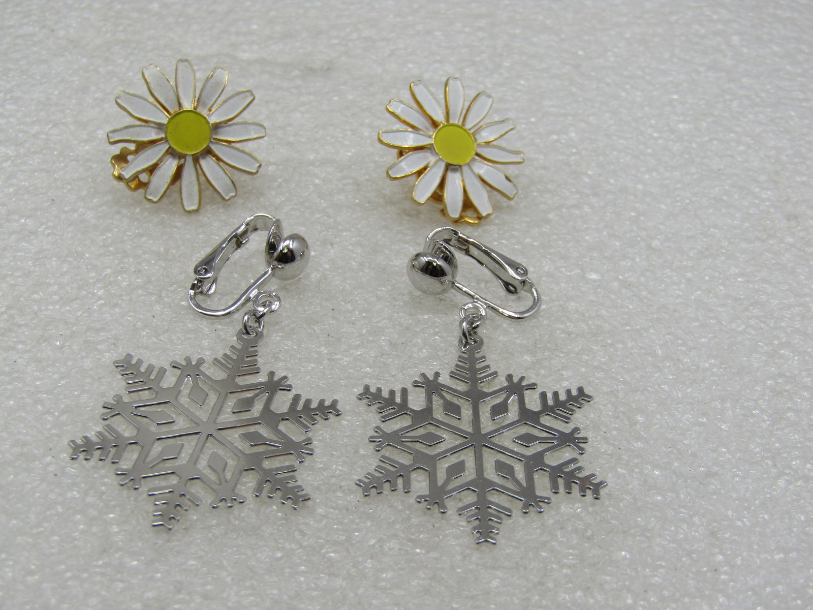 Vintage Daisy & Snowflake Earrings. Clip, 2 Pr.: Vintage Daisy & Snowflake Earrings. Clip, 2 Pr. Silver Tone Snowflake Signed Avon, 1.5" long and 1" wide. Yellow & white enameled daisy stud clip earrings, gold tone. Not signed. A pair for two