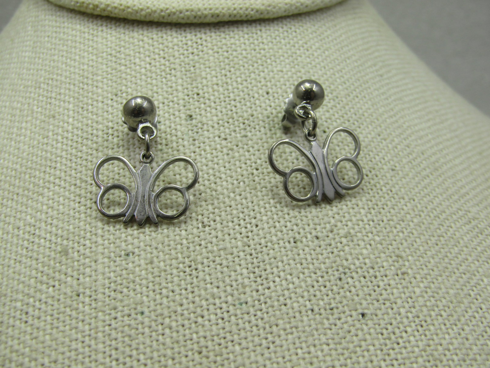 Vintage Silver Tone Butterfly Earrings, Pierced, Stud/Dangle: Vintage Silver Tone Butterfly Earrings, Pierced, Stud/Dangle. 1970's-1980's. 5mm stud ball from which the 3/4" by 5/8" butterfly dangles. It is flat with open opens. It is not signed by the