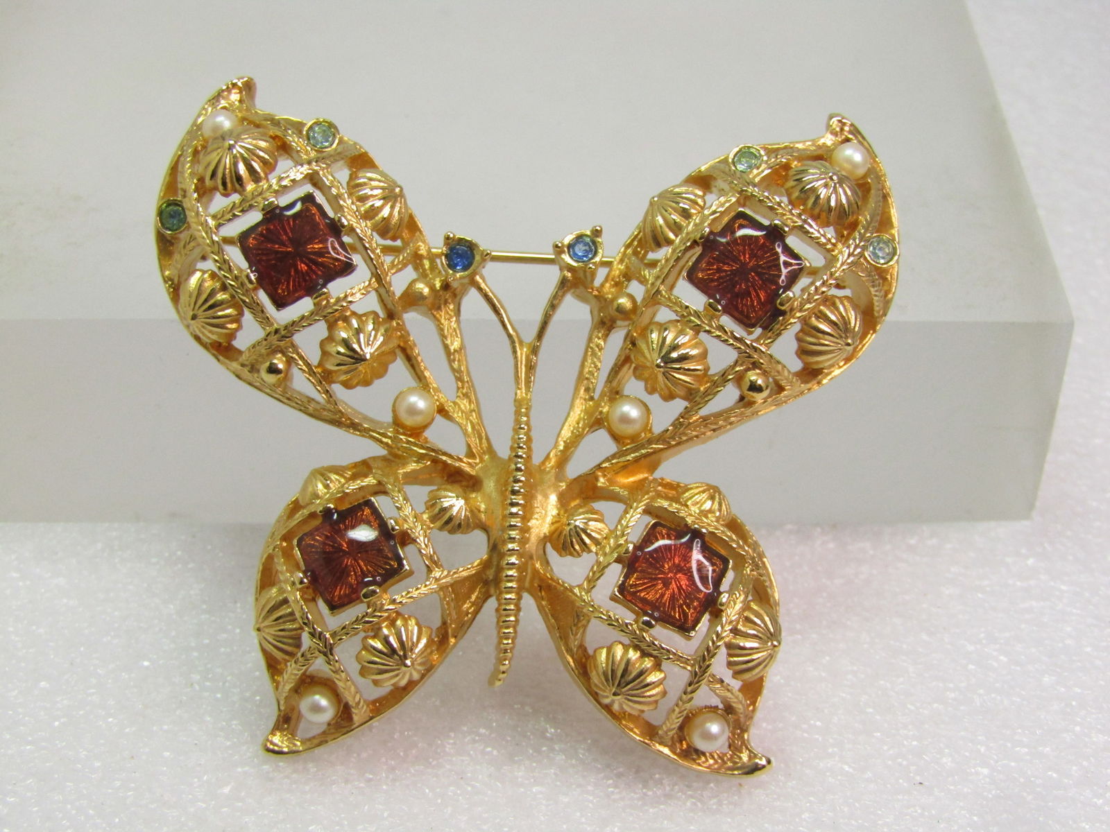 Vintage Avon Enameled Butterfly Brooch - Rhinestones/Faux Pearls, 1980's: Vintage Avon Enameled Butterfly Brooch - Rhinestones/Faux Pearls, 1980's. Gold tone with amber enameled square accents - one in each wing and blue rhinestones at the t ip of the antenna and in the fro