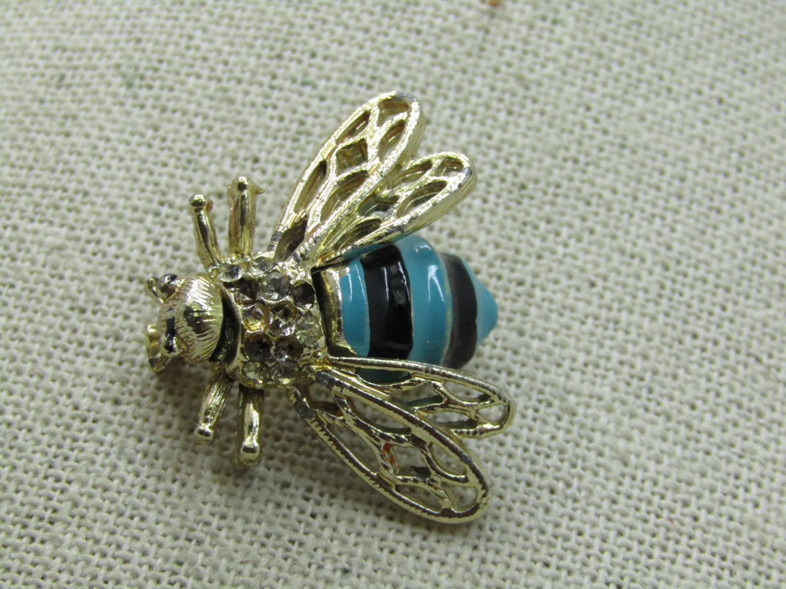 Vintage Enameled Bee Brooch, Rhinestones, 1960's: Vintage Enameled Bee Brooch, Rhinestones, 1960's. Enameled with turquoise and black sripes and rhinestones behind the head. This ws missing rhinestones which have been replaced. Gold tone. it is appx.