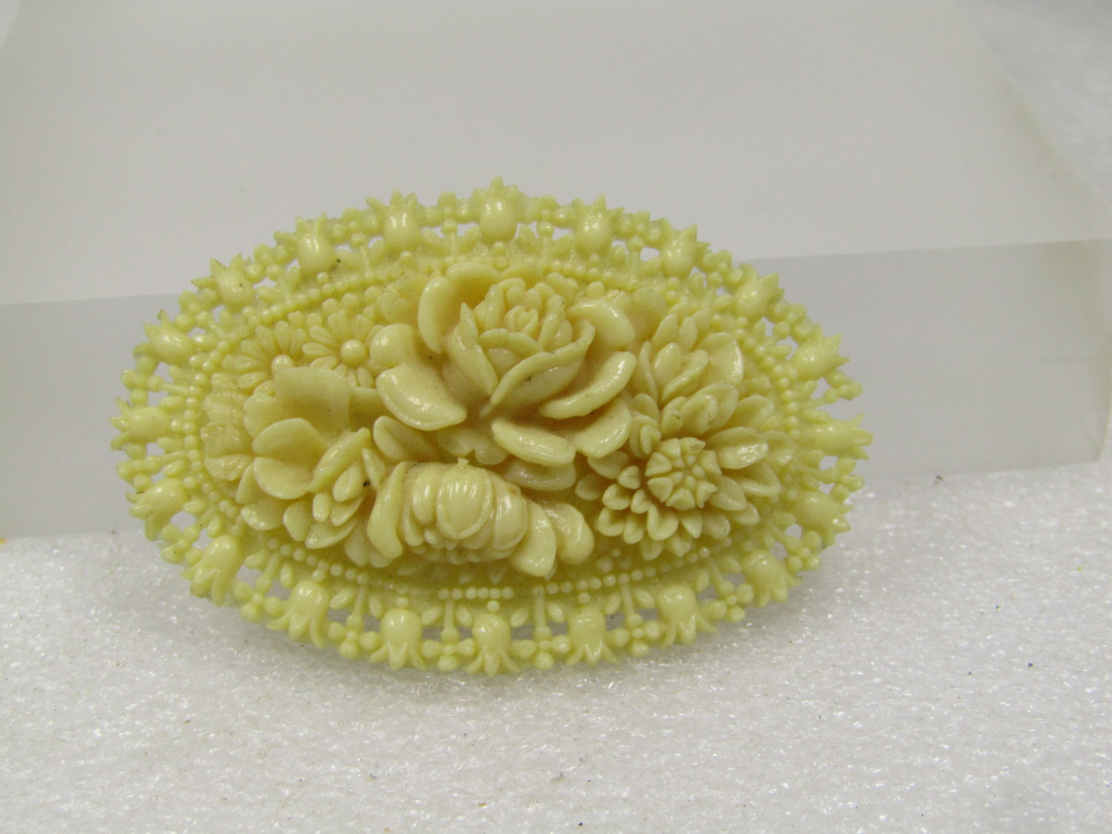 Vintage White Celluloid Floral Brooch, Japan, 1930's-1950's, C-Clasp: Vintage White Celluloid Floral Brooch, Japan, 1930's-1950's, C-Clasp. This is a white oval celluloid brooch with raised blossoms and other accents. The frame has tulips and the center roses. There