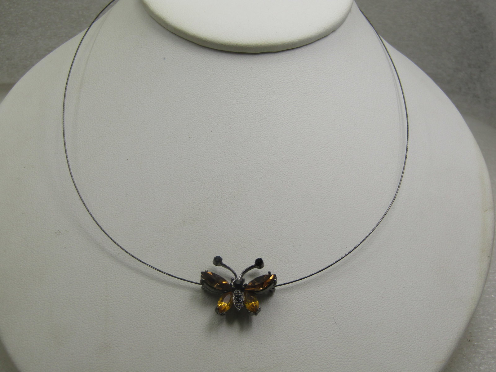 Rhinestone Butterfly Slide Necklace, 18": Rhinestone Butterfly Slide Necklace, 18". This is a thin coated wire chain that is 16" with a 2" extender chain and a brown and yellow rhinestone butterfly pendant that moves easily on the necklace.